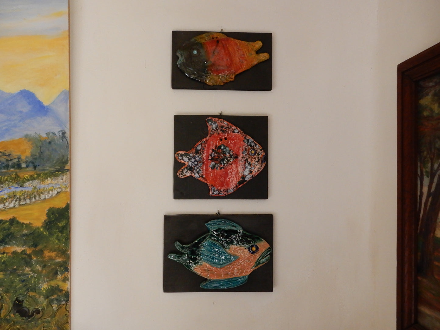 Pesci_in_ceramica_scultura_su_supporto_in_legno, foto espositiva pesce uncinetto , muso nero, prepotente