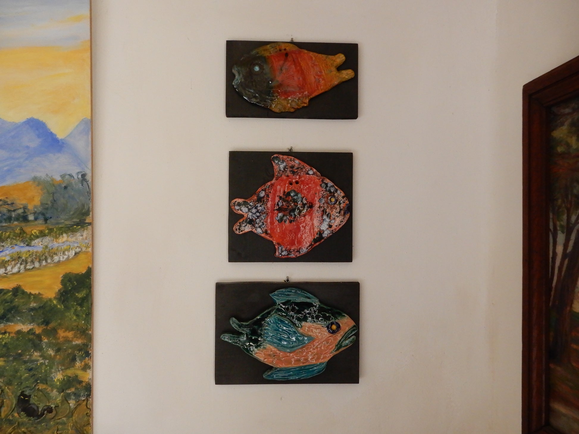 Pesci_in_ceramica_scultura_su_supporto_in_legno, foto espositiva pesce uncinetto , muso nero, prepotente